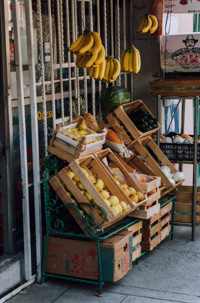 pexels-photo-12329779-12329779 Vibrant display of bananas and citrus fruits at an outdoor market.