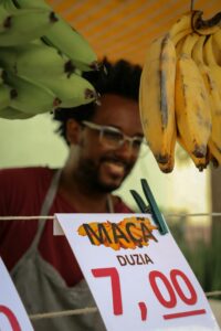 Bananas for sale by street vendor in São Paulo market, vibrant and candid moment captured.