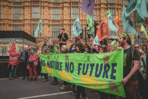 Protesters in London hold a banner advocating for environmental conservation. City streets echo with calls for action.